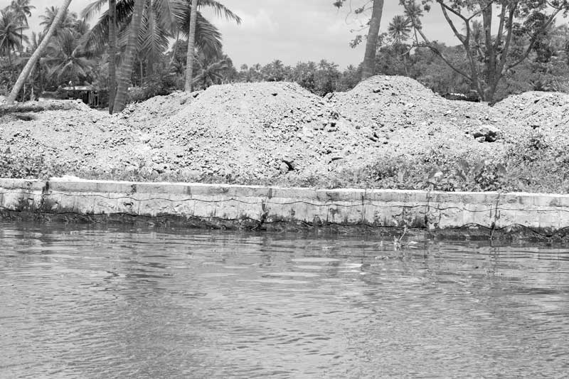 Living Below the Sea Level - An embankment along a channel of river Pamba being filled up for developing a new settlement in Alappuzha district, Kerala